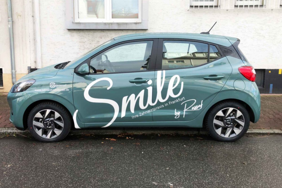 Fahrzeugbeschriftung mit Smile Schriftzug über die Seitenflächen