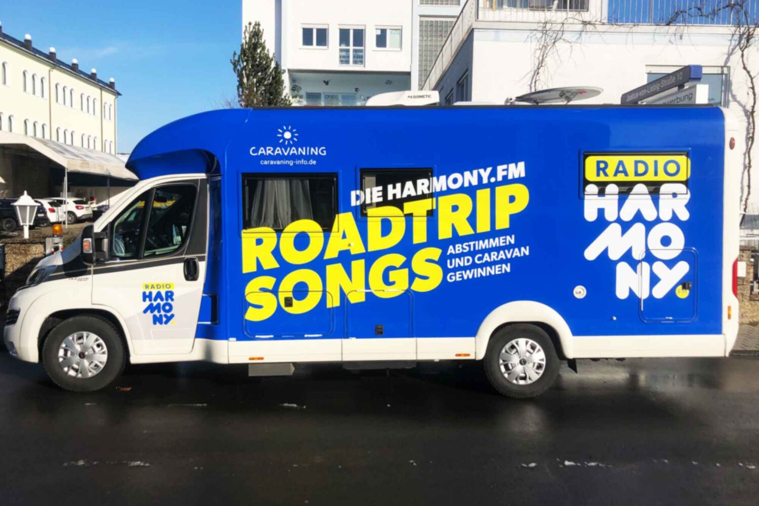 Vollverklebung-Harmony Fahrzeugbeschriftung für Harmonie FM Vollverklebung in Blau mit Plotts Auto vor unserer Halle in Dietzenbach