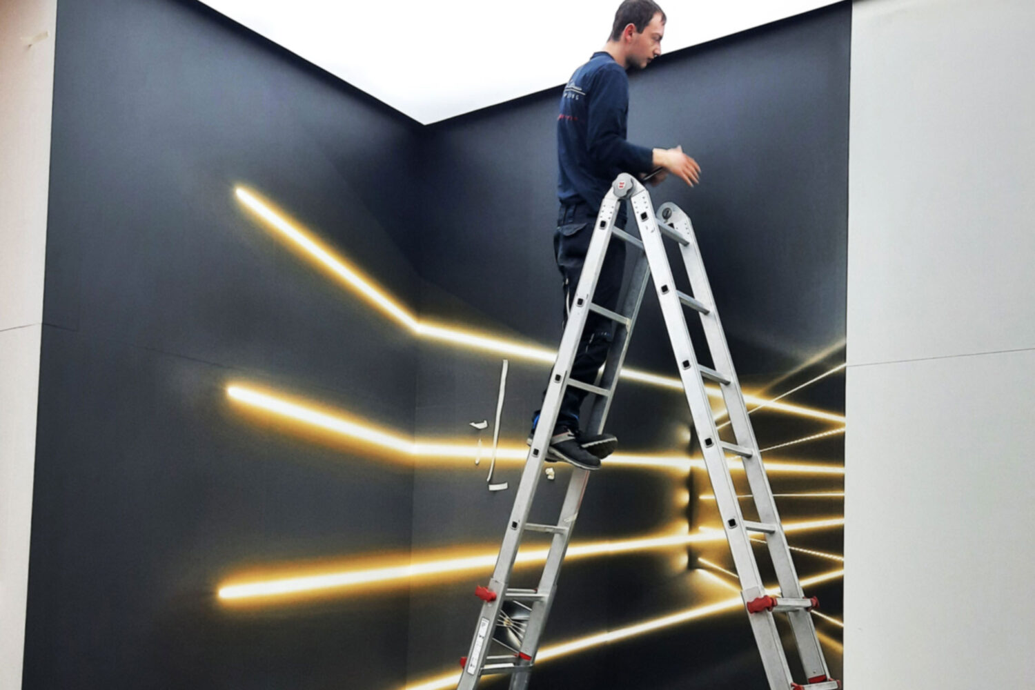 verklebearbeiten-von-Digitaldruckfolien Wandgestaltung mit Lampenmotiv Mitarbeiter beim Verkleben